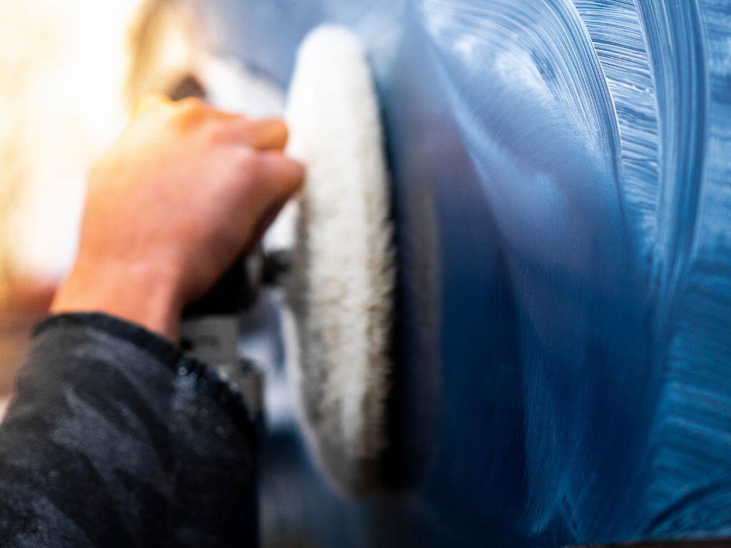 Close-up of a technician polishing a boat's gelcoat to achieve a high-gloss finish as part of the gelcoat restoration process by A1 Marine Care.