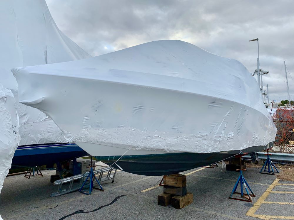 Boat prepared for winter storage with professional shrink wrap, protecting the vessel from harsh weather conditions.